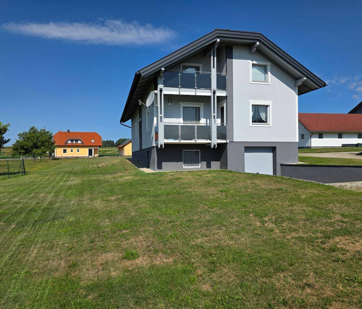 Modernes Einfamilienhaus mit Balkonen und weitem Blick auf die Umgebung.