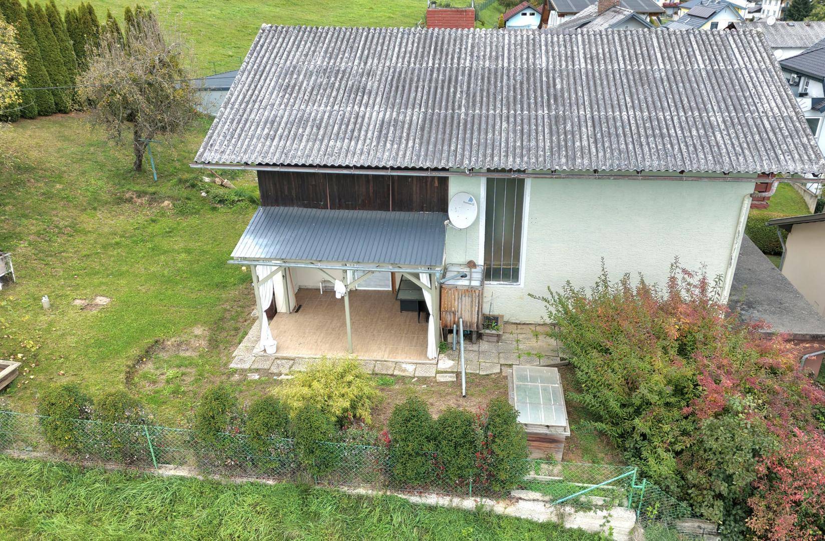 Rückseite des Hauses mit überdachter Terrasse und Zugang zum Gartenbereich.