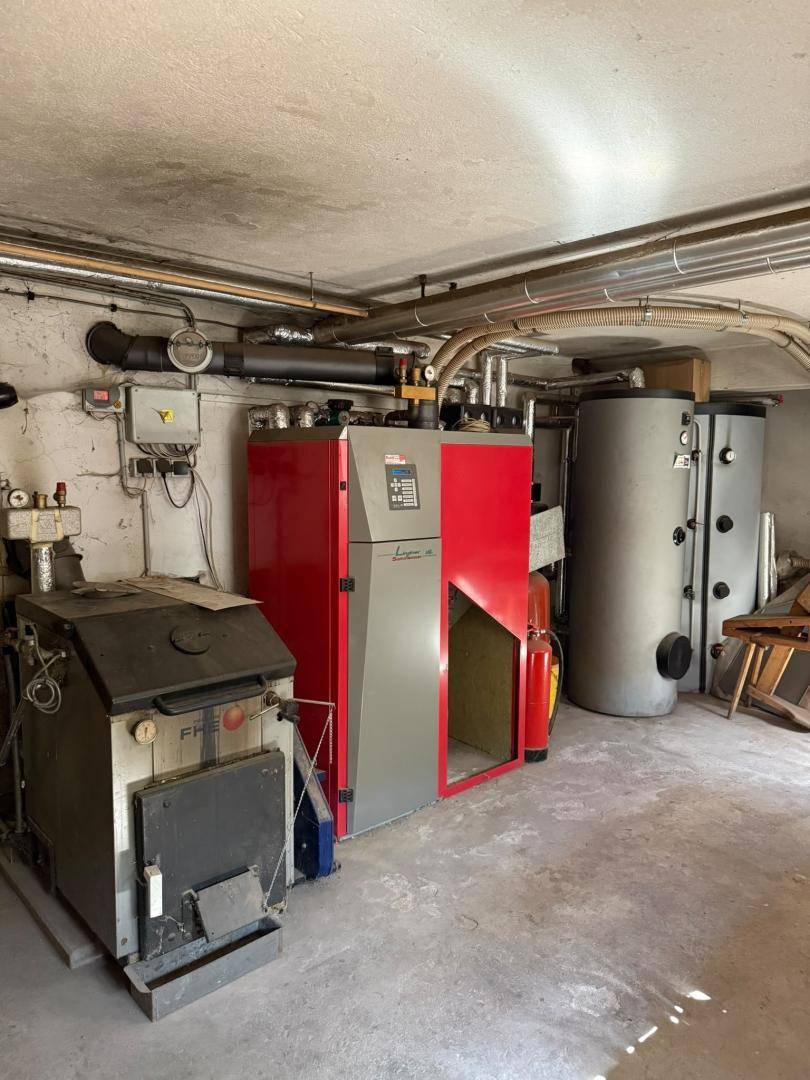 Heizungsraum im Keller mit großem Heizkessel und Warmwasserspeichern.