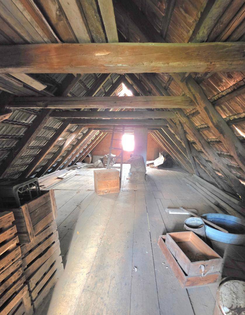 Geräumiger Dachboden mit Holzboden und sichtbarer Dachkonstruktion, ideal als Lagerfläche.