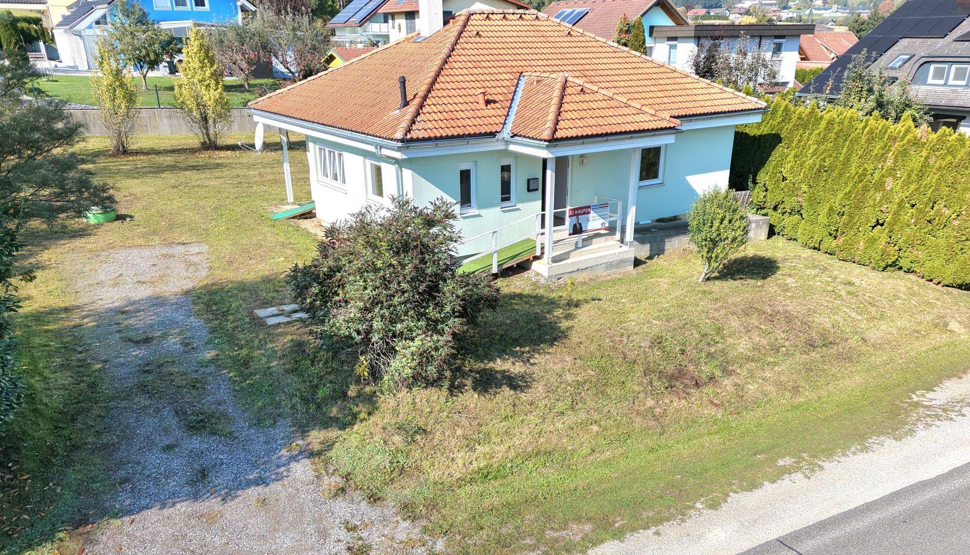 Ansicht des Einfamilienhauses von vorne mit Vorgarten und Zufahrt.