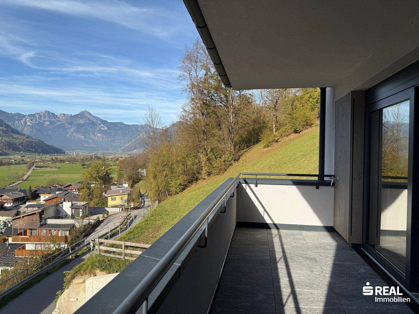 Geräumiger Balkon mit weitem Blick auf die umliegende Berglandschaft und grüne Hänge.
