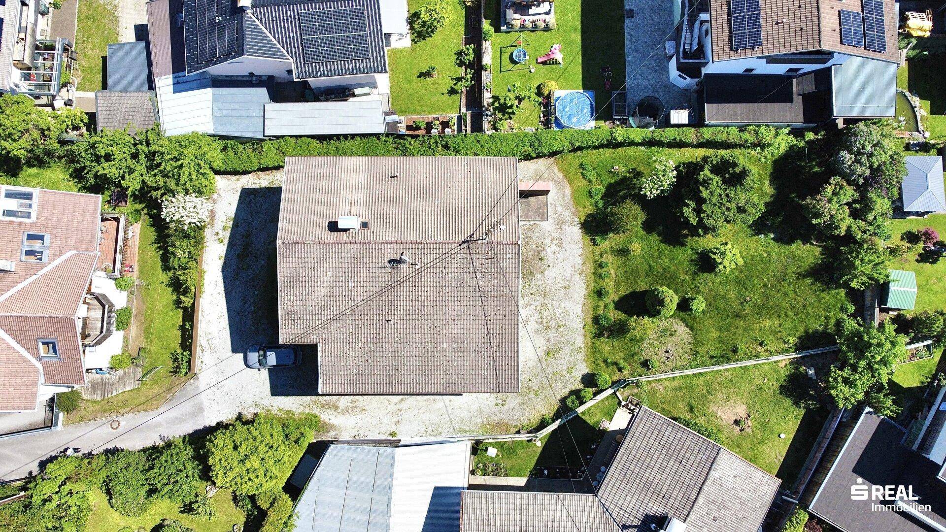Draufsicht auf das Grundstück mit Haus, Garten und angrenzenden Gebäuden.