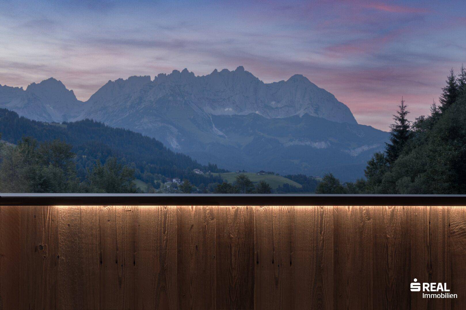 Balkon mit Holzbrüstung und atemberaubendem Blick auf die umliegende Berglandschaft.