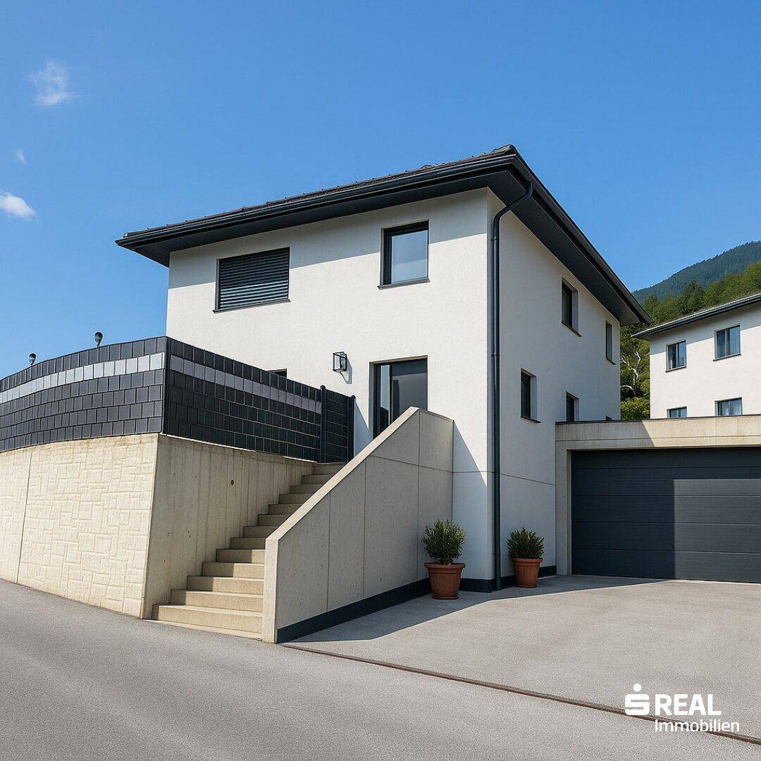 Ansicht des modernen Einfamilienhauses mit Garage, Treppenaufgang und gepflegter Außenanlage.