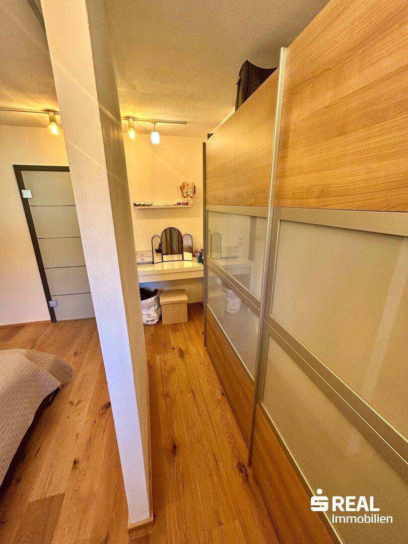 Schlafzimmer mit Holzboden und Schiebetürenschrank, bietet eine moderne und platzsparende Lösung.