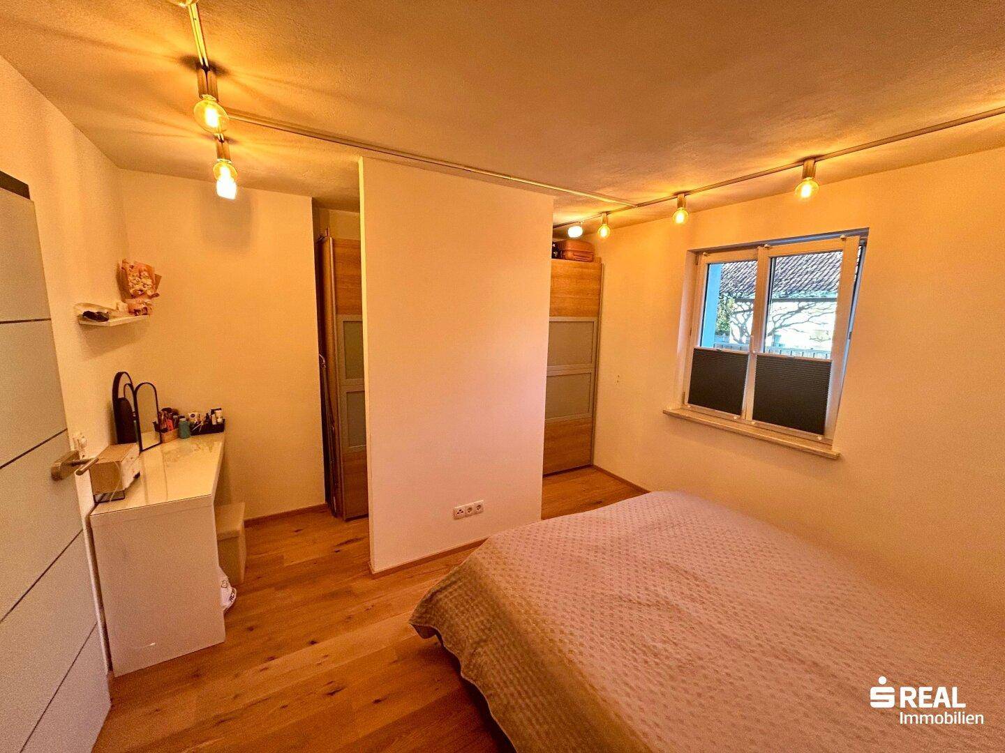 Geräumiges Schlafzimmer mit Holzboden und Fenster, bietet Komfort und Funktionalität.