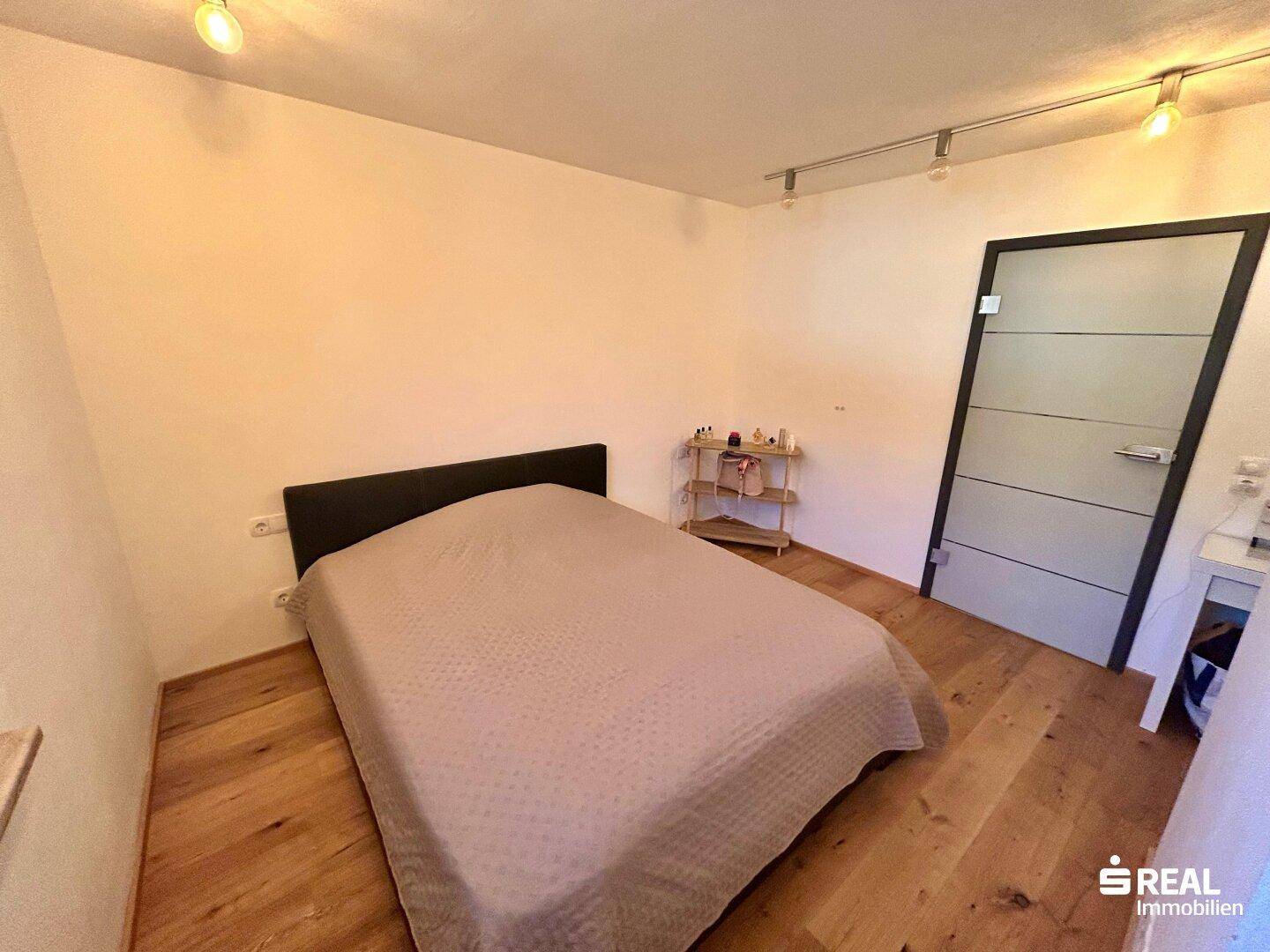 Schlafzimmer mit Holzboden und Doppelbett, bietet eine ruhige und entspannende Atmosphäre.