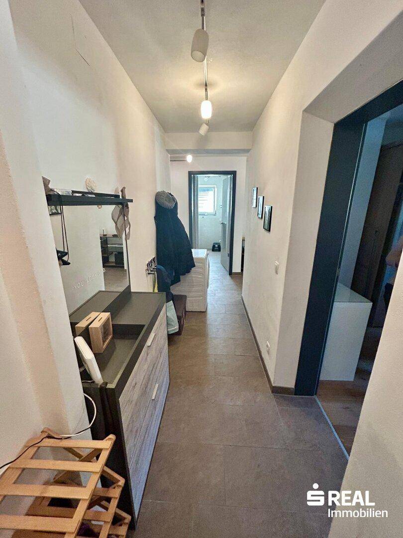 Eingangsbereich mit Fliesenboden und Garderobe, bietet praktischen Stauraum für Kleidung und Schuhe.