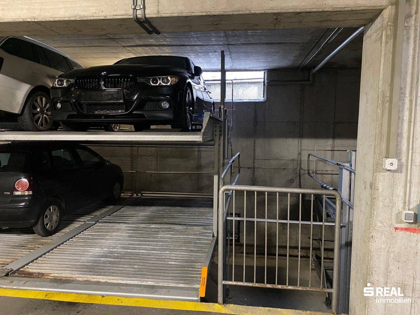 Tiefgarage mit modernen Parksystemen für mehrere Fahrzeuge, bietet effiziente Raumnutzung.