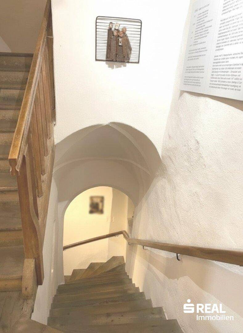 Historisches Treppenhaus mit Holzgeländer und Gewölbedecke, das zu den oberen Etagen dieses Altbaus führt.