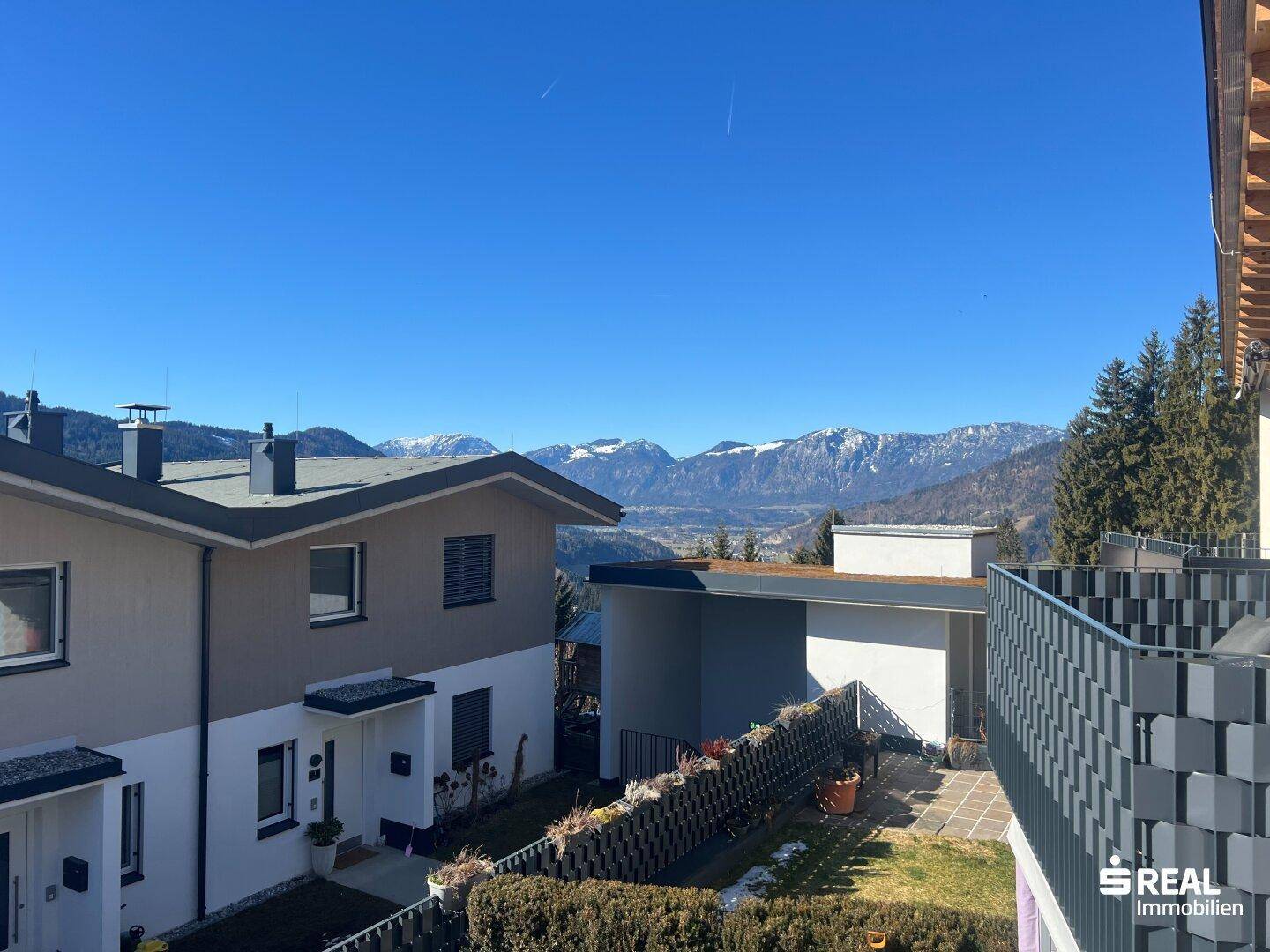 Panoramablick auf die umliegende Berglandschaft und benachbarte Häuser.