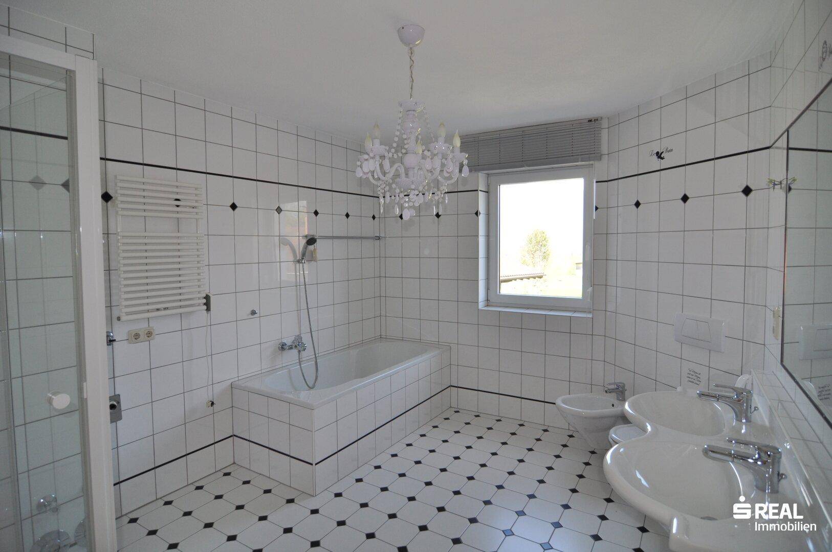 Großes Badezimmer mit Badewanne, Dusche, Doppelwaschbecken und Bidet.