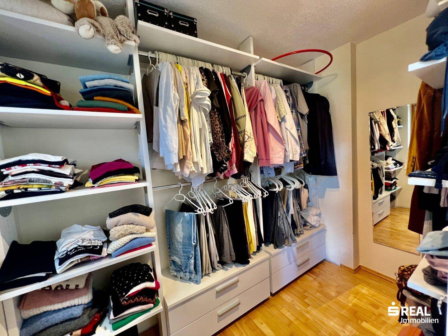 Begehbarer Kleiderschrank mit Regalen und viel Stauraum für Kleidung und Accessoires.