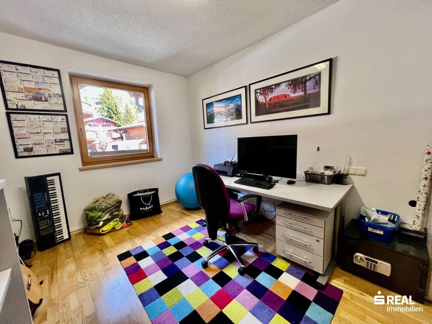 Helles Arbeitszimmer mit Schreibtisch, Bürostuhl und Holzboden, ideal für Home-Office.