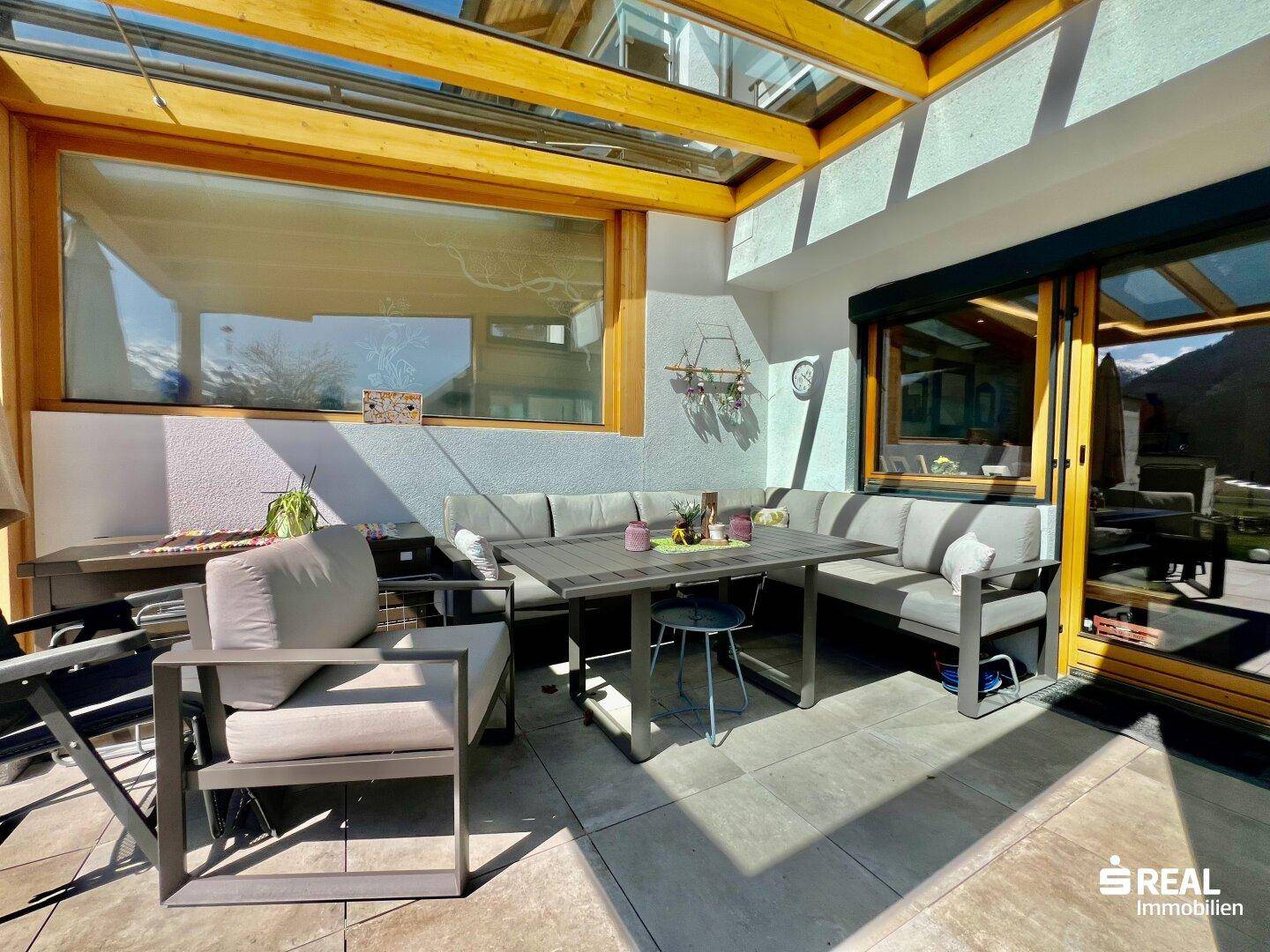 Überdachte Terrasse mit modernen Gartenmöbeln, ideal für entspannte Stunden im Freien.