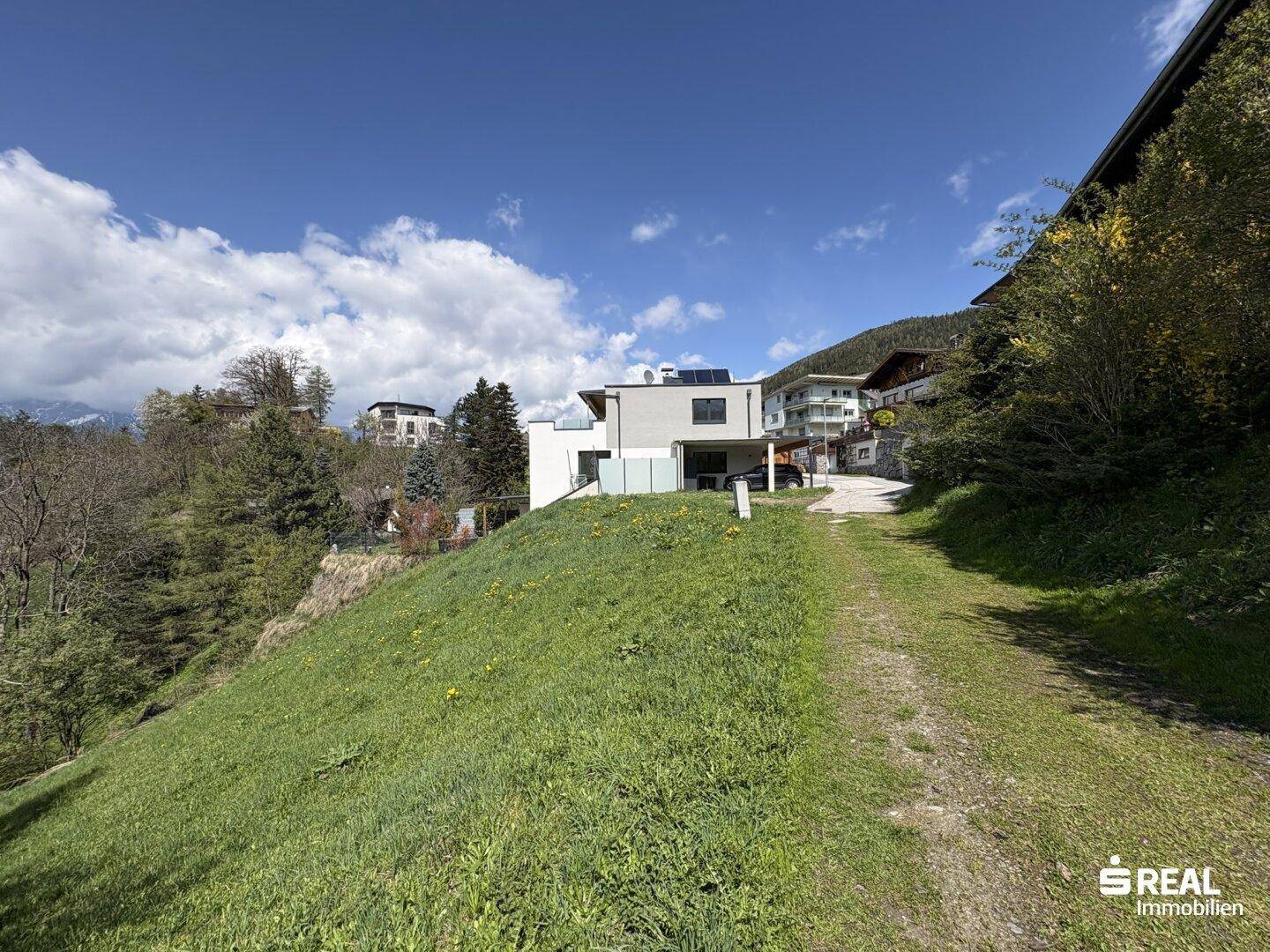 Das moderne Haus in Hanglage mit weitem Blick über die umliegende Landschaft.
