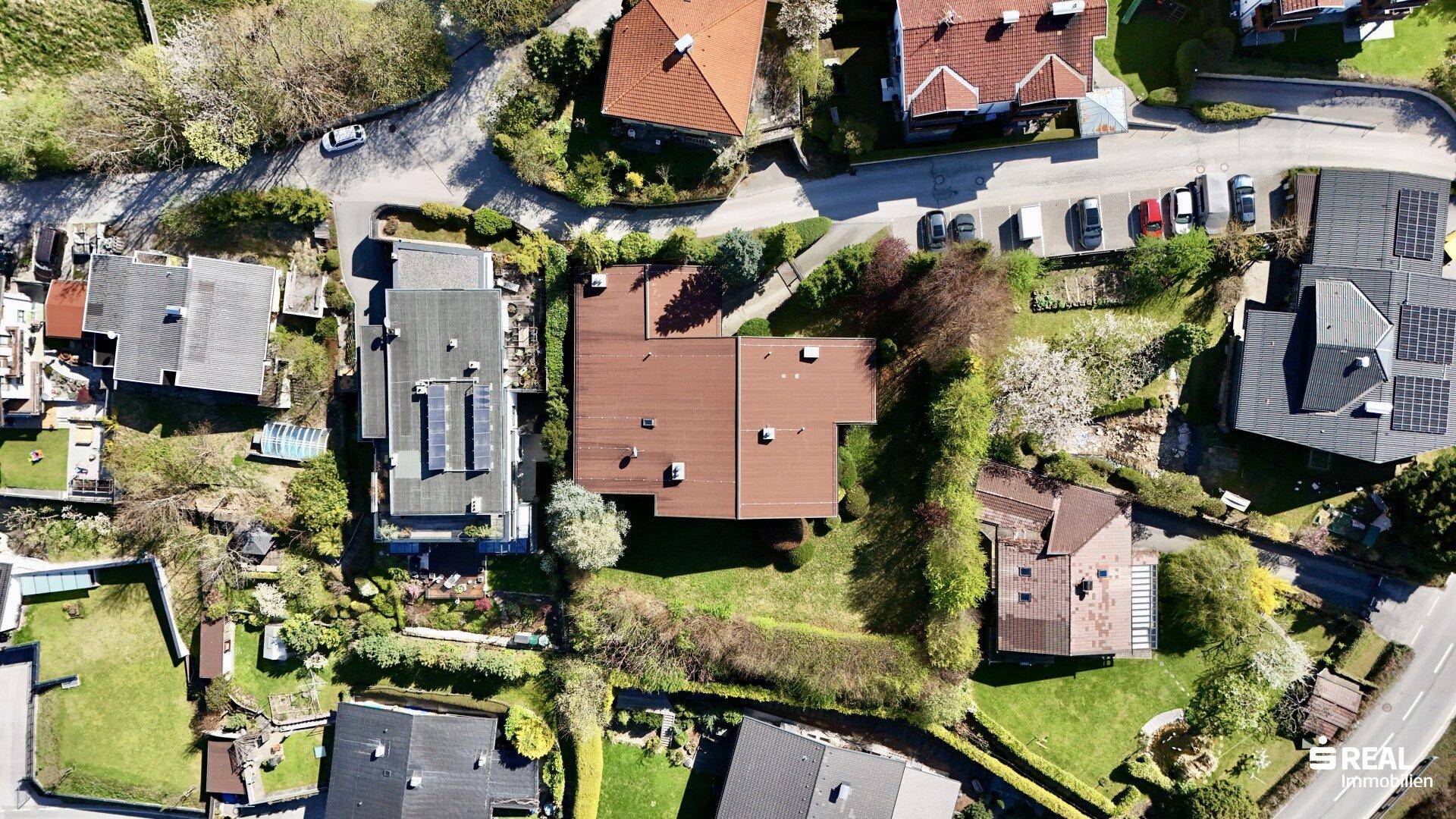Vogelperspektive des Anwesens mit braunem Dach, umgeben von Gärten und einer ruhigen Wohngegend.