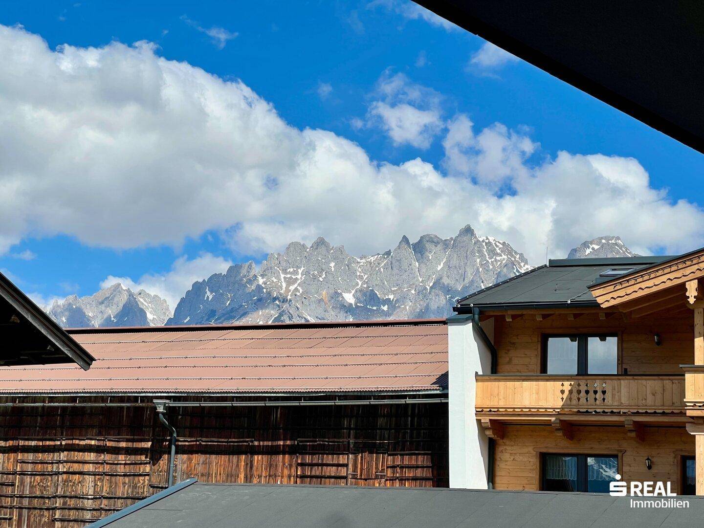 Spektakulärer Bergblick mit schneebedeckten Gipfeln unter einem blauen Himmel.
