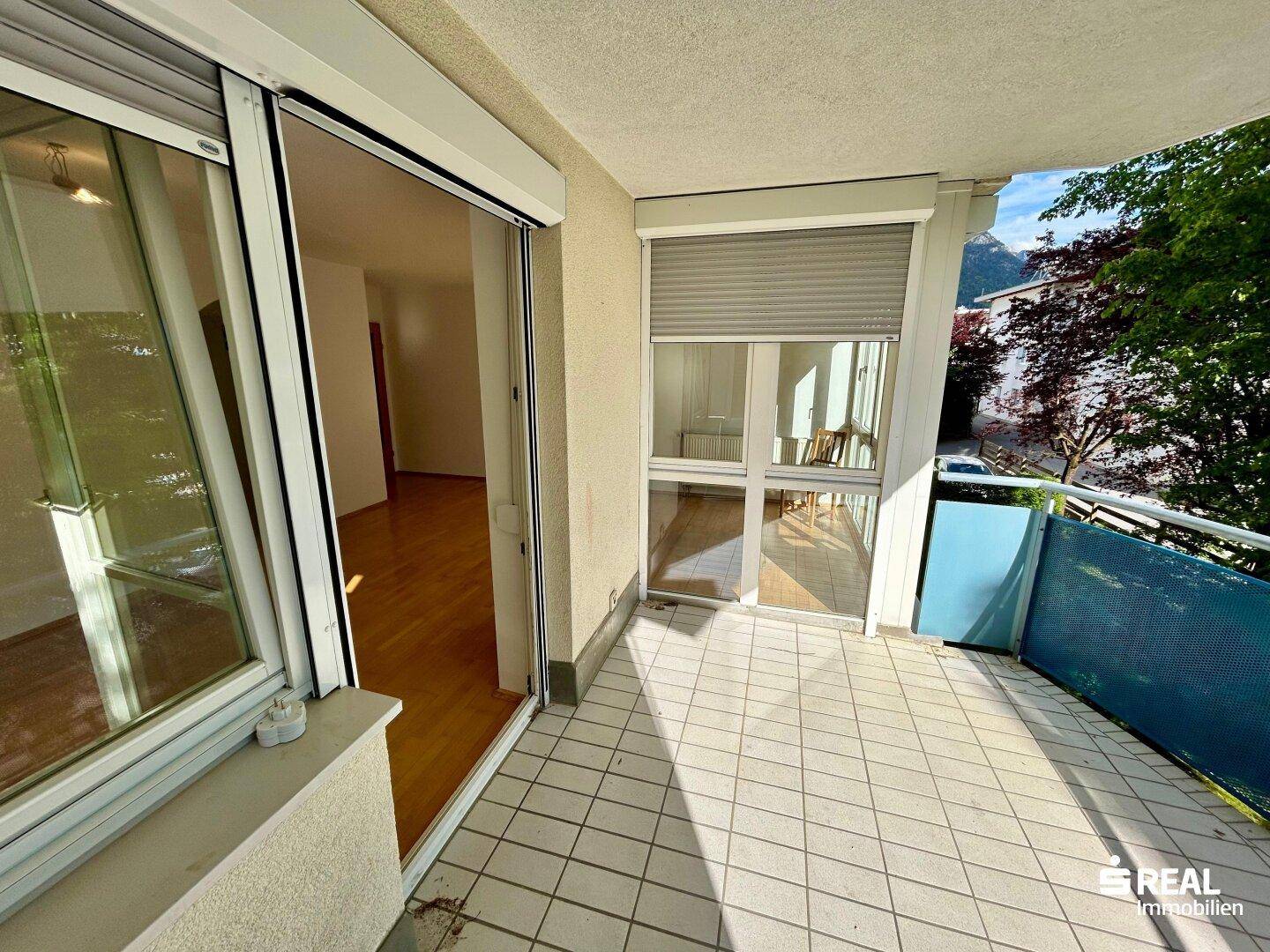 Geräumiger Balkon mit Fliesenboden und Zugang zu den Innenräumen.