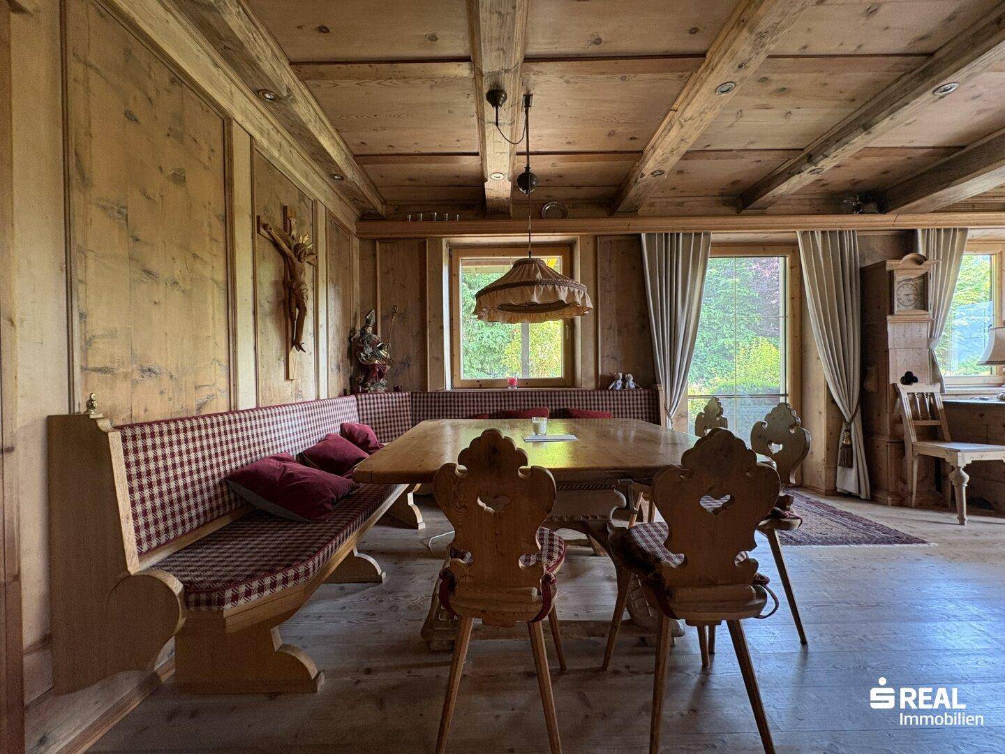 Rustikaler Essbereich mit Holzwänden, Holzbalkendecke und traditionellen Sitzgelegenheiten.