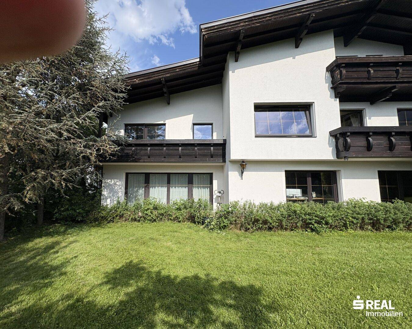 Weitläufiger Gartenbereich mit Rasen und der Rückseite des Hauses.