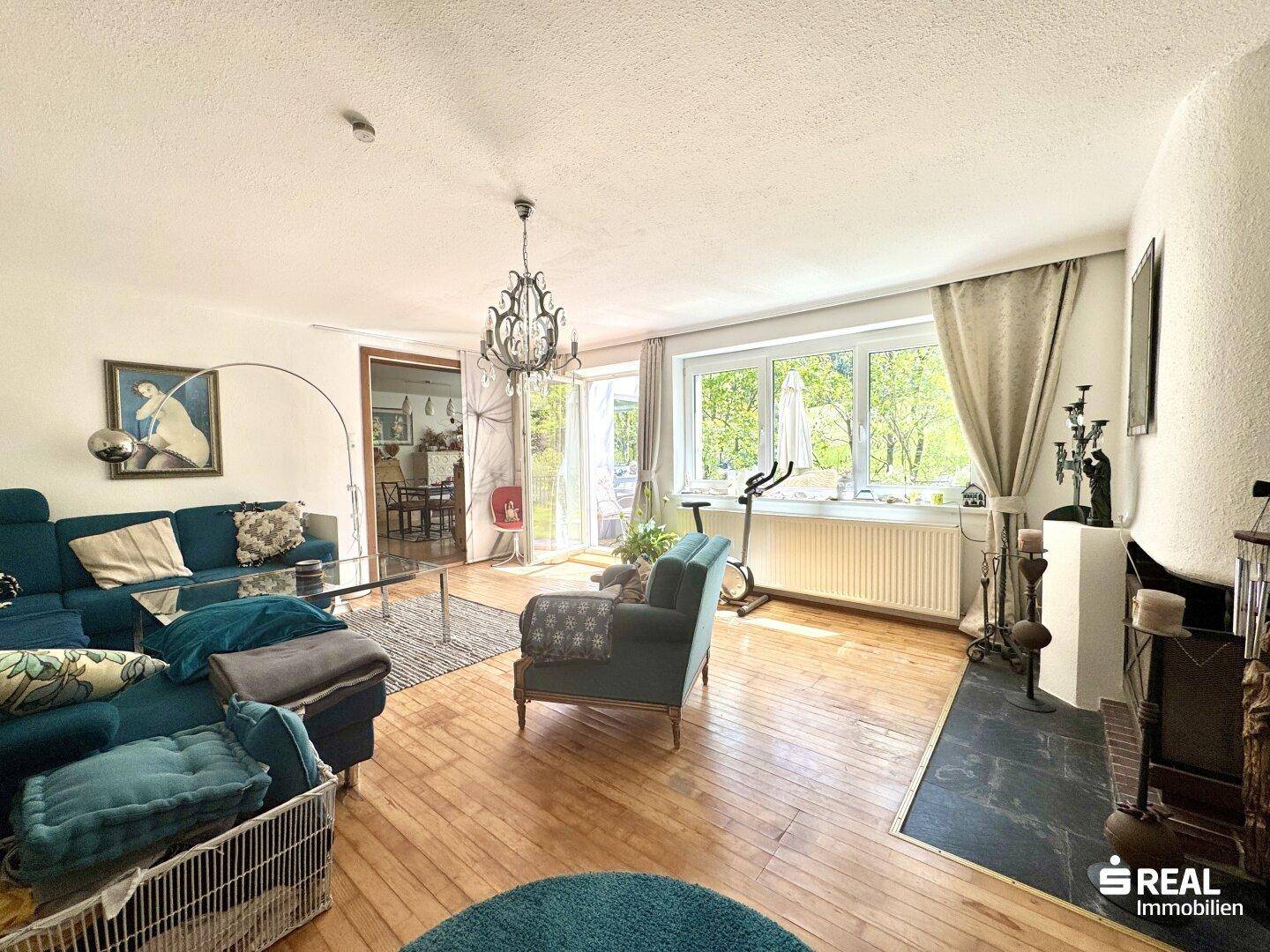 Helles Wohnzimmer mit Holzboden, bequemen Sofas und Zugang zur Terrasse.