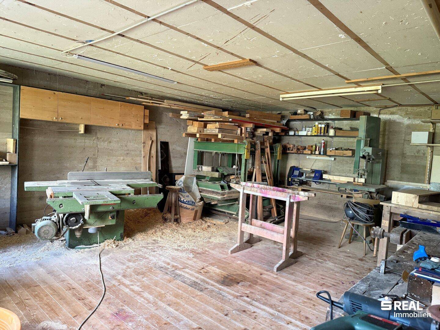 Geräumige Werkstatt mit verschiedenen Holzbearbeitungsmaschinen und viel Stauraum für Materialien.