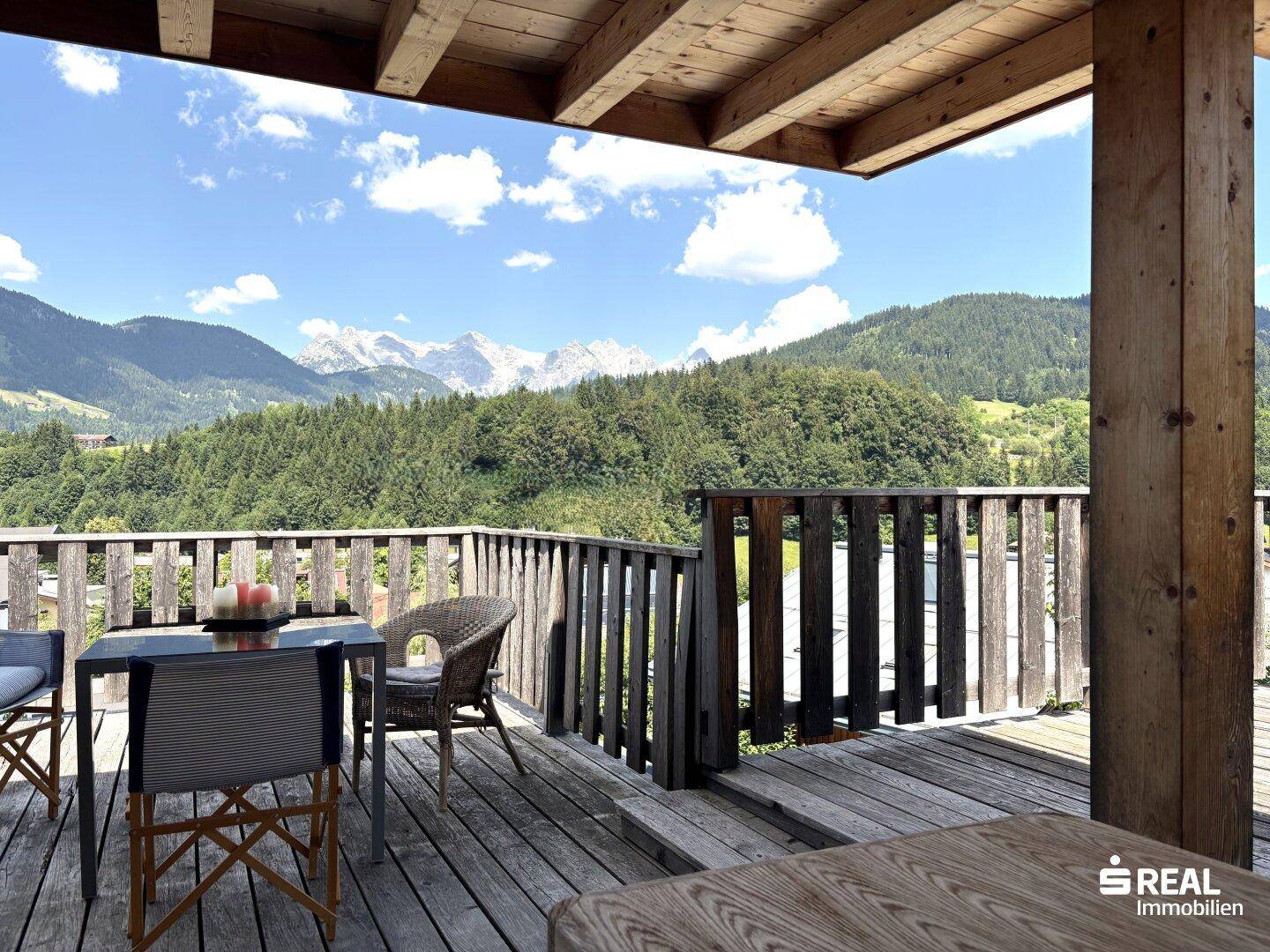 Gemütliche Holzterrasse mit Sitzgelegenheiten und atemberaubendem Bergblick.