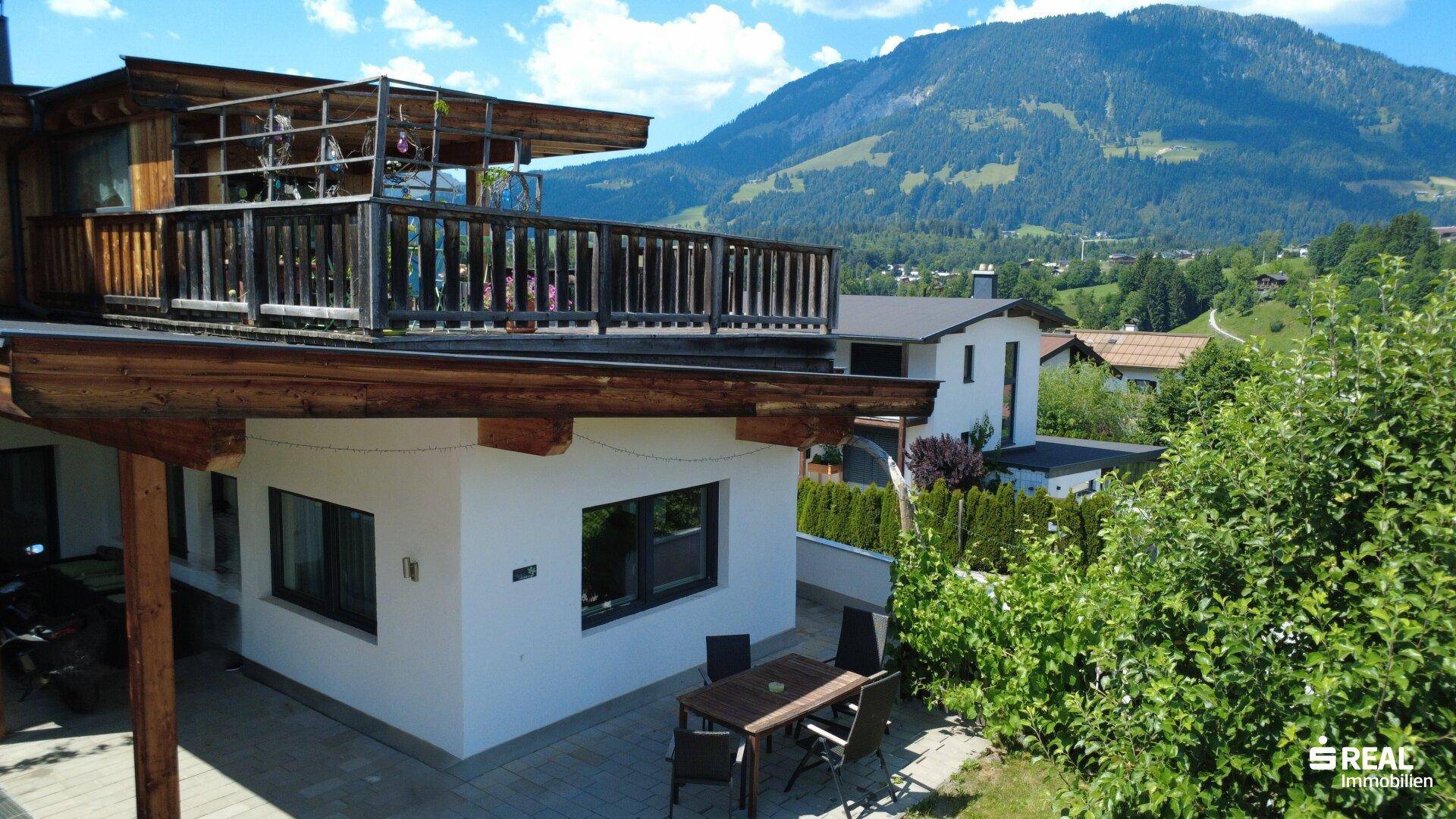 Außenansicht des Hauses mit einer möblierten Terrasse und Blick auf die umliegende Natur.