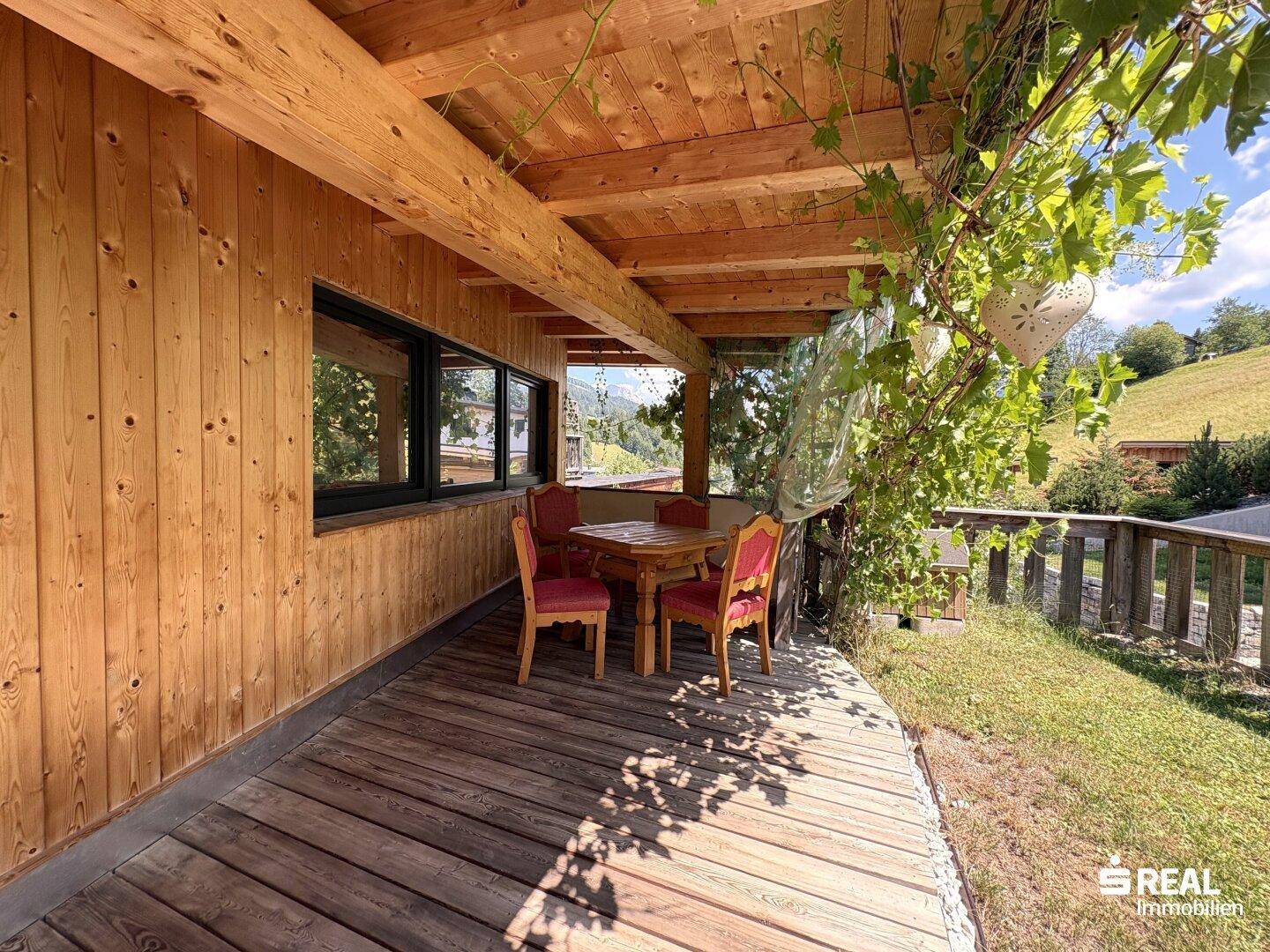 Überdachter Außenbereich mit Holzwänden und -decke, ideal für Mahlzeiten im Freien.