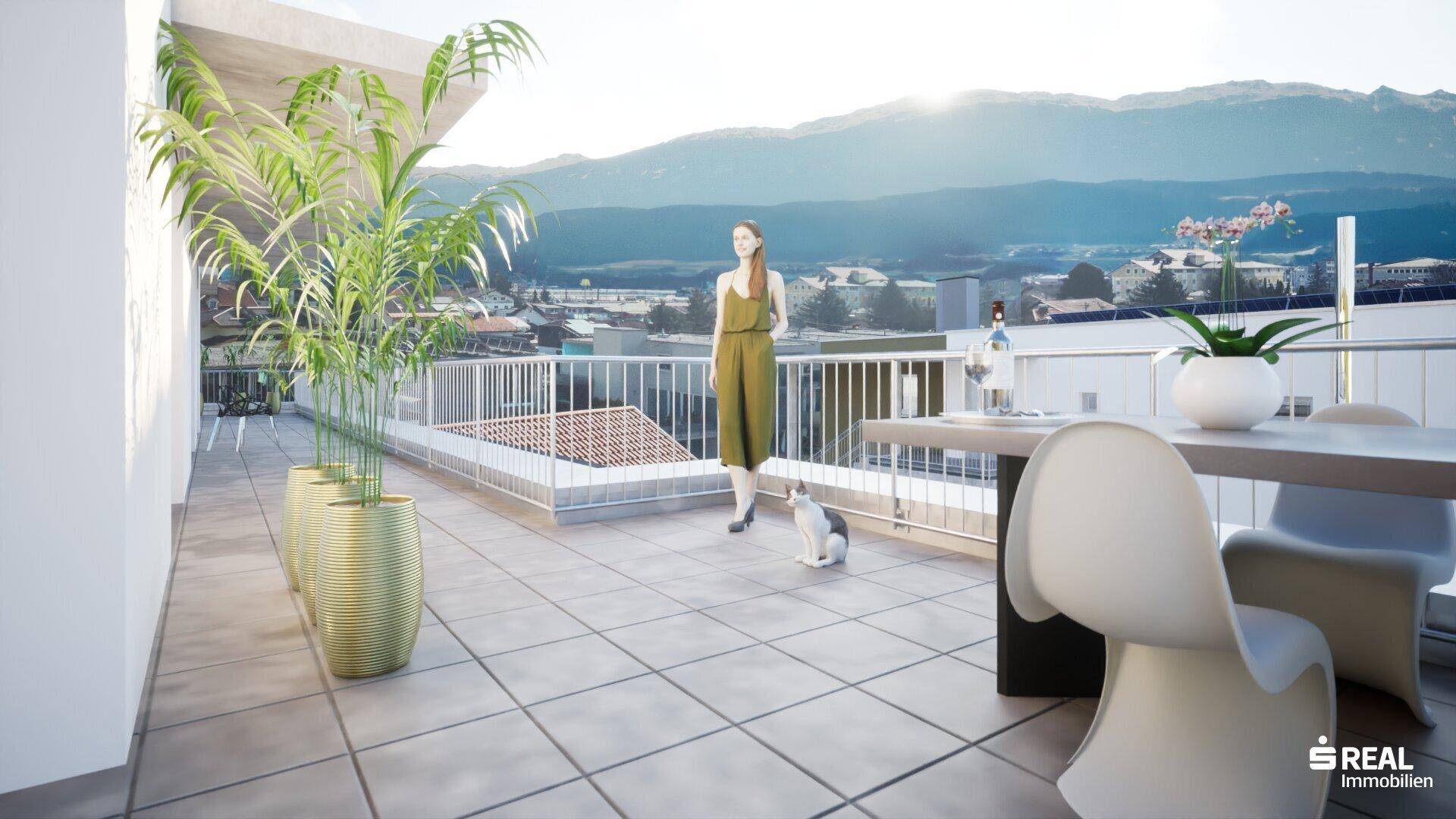 Sonniger Terrassenbereich mit Esstisch, Pflanzen und weitem Blick auf die umliegende Berglandschaft.