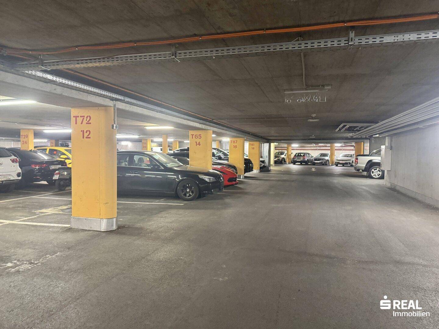 Tiefgarage mit zahlreichen Parkplätzen und gelben Säulen.