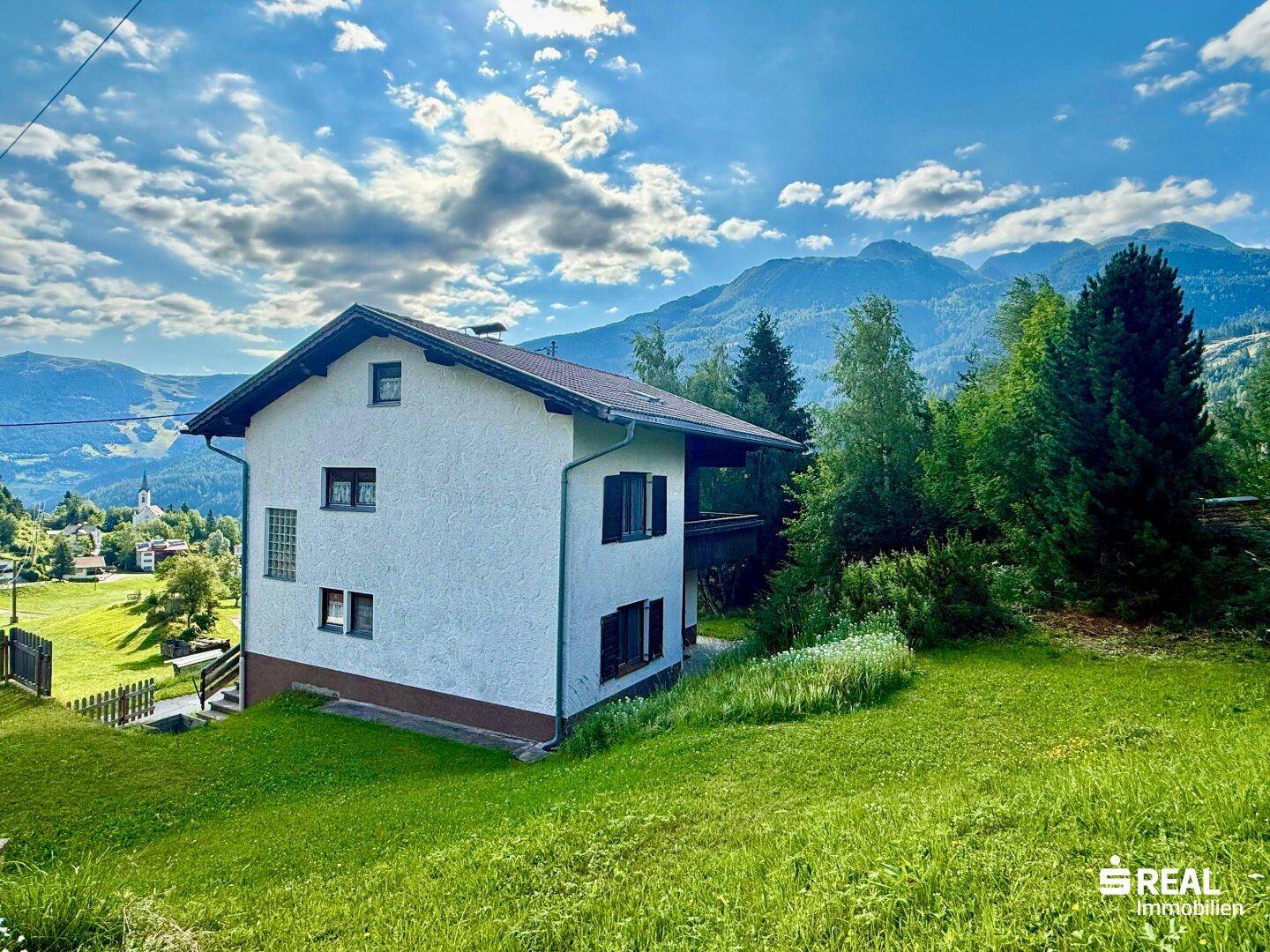 Freistehendes Haus in idyllischer Lage mit weitem Blick auf die Bergwelt und grüne Wiesen.