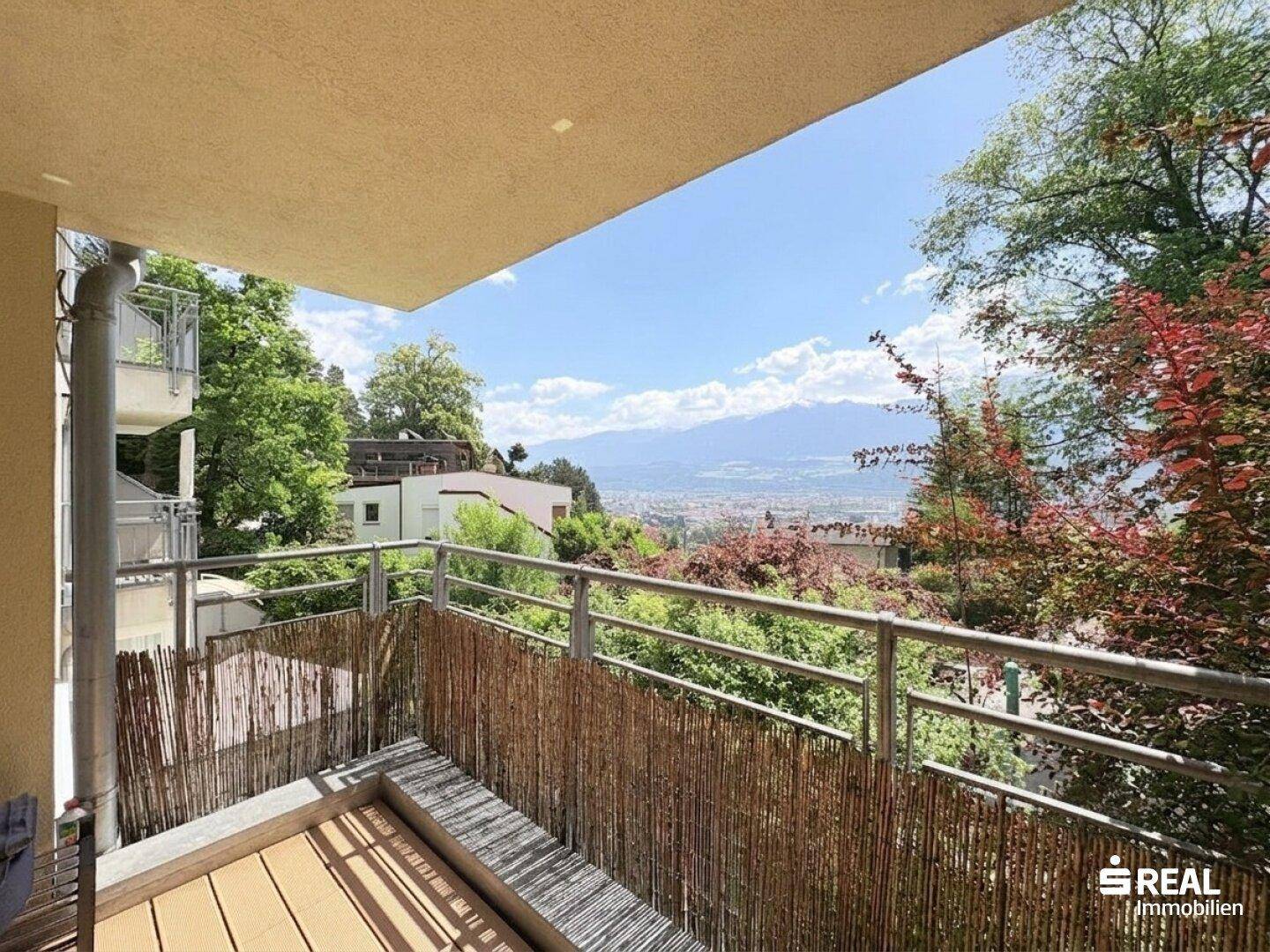 Sonniger Balkon mit weitem Blick über die Stadt und die umliegende Berglandschaft.