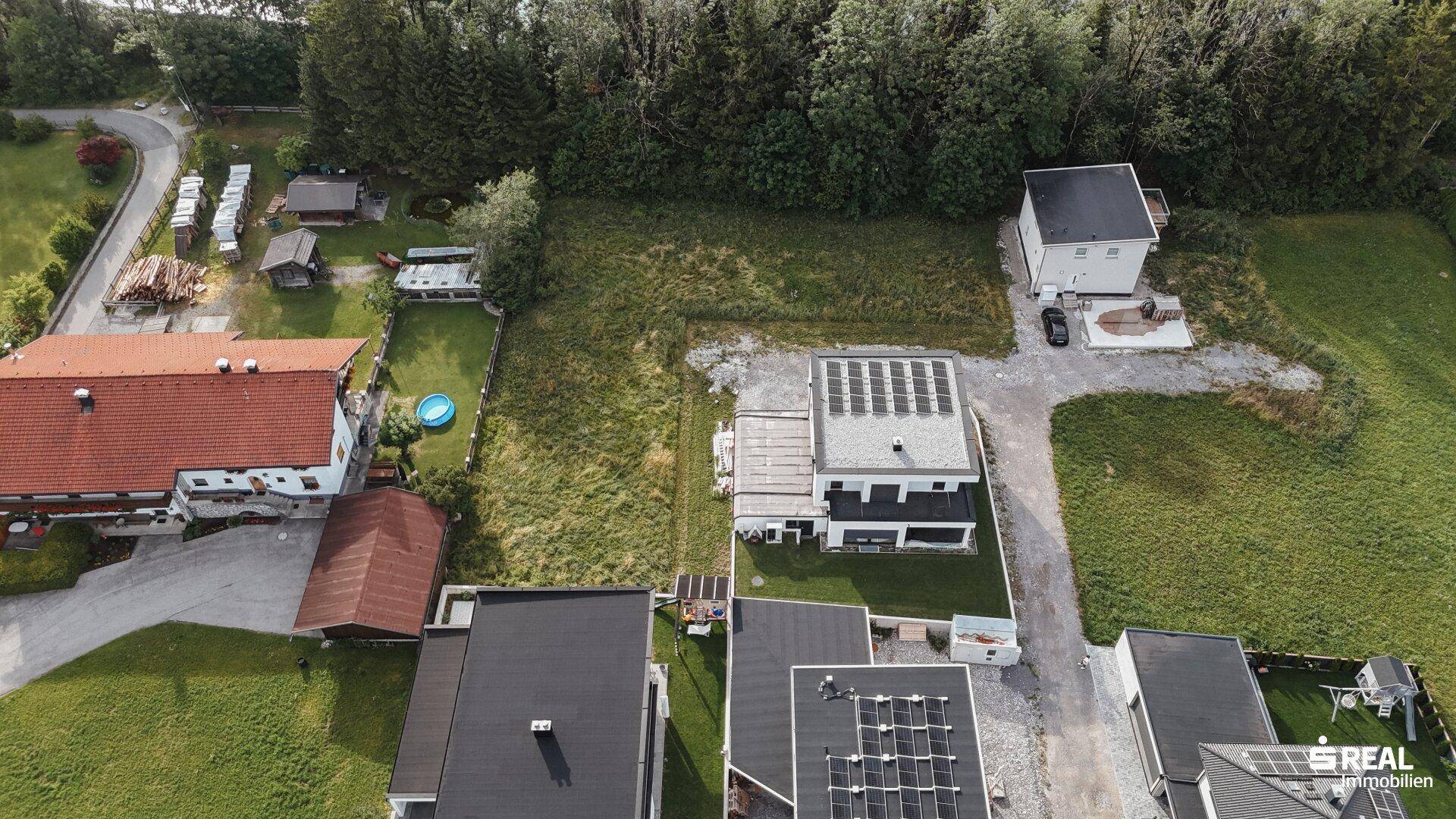 Panoramablick aus der Luft auf die Wohnsiedlung mit freien Grundstücken und Neubauten.