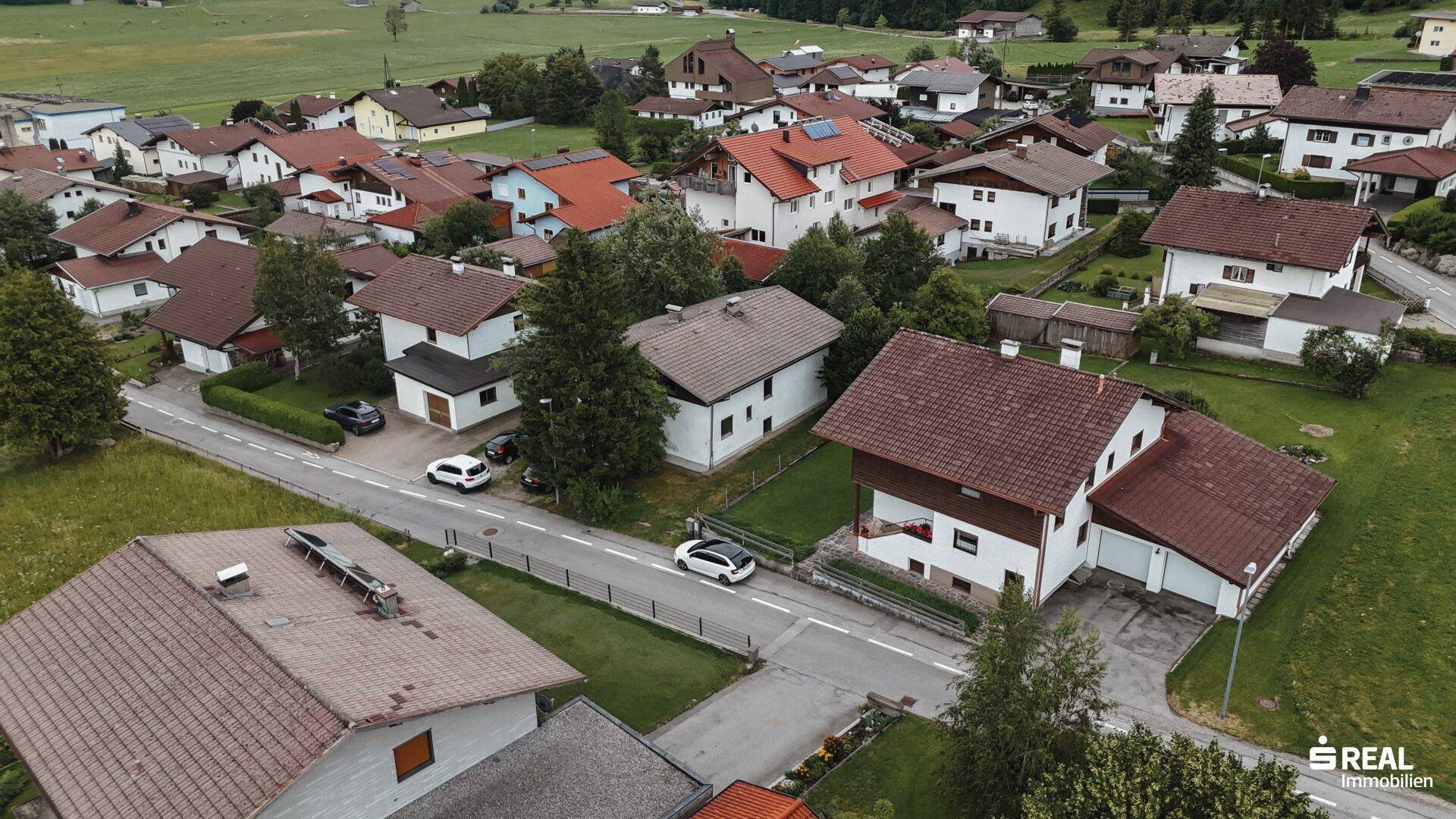 Panoramablick auf eine Wohngegend mit traditionellen Häusern und weitläufigen Grünflächen.