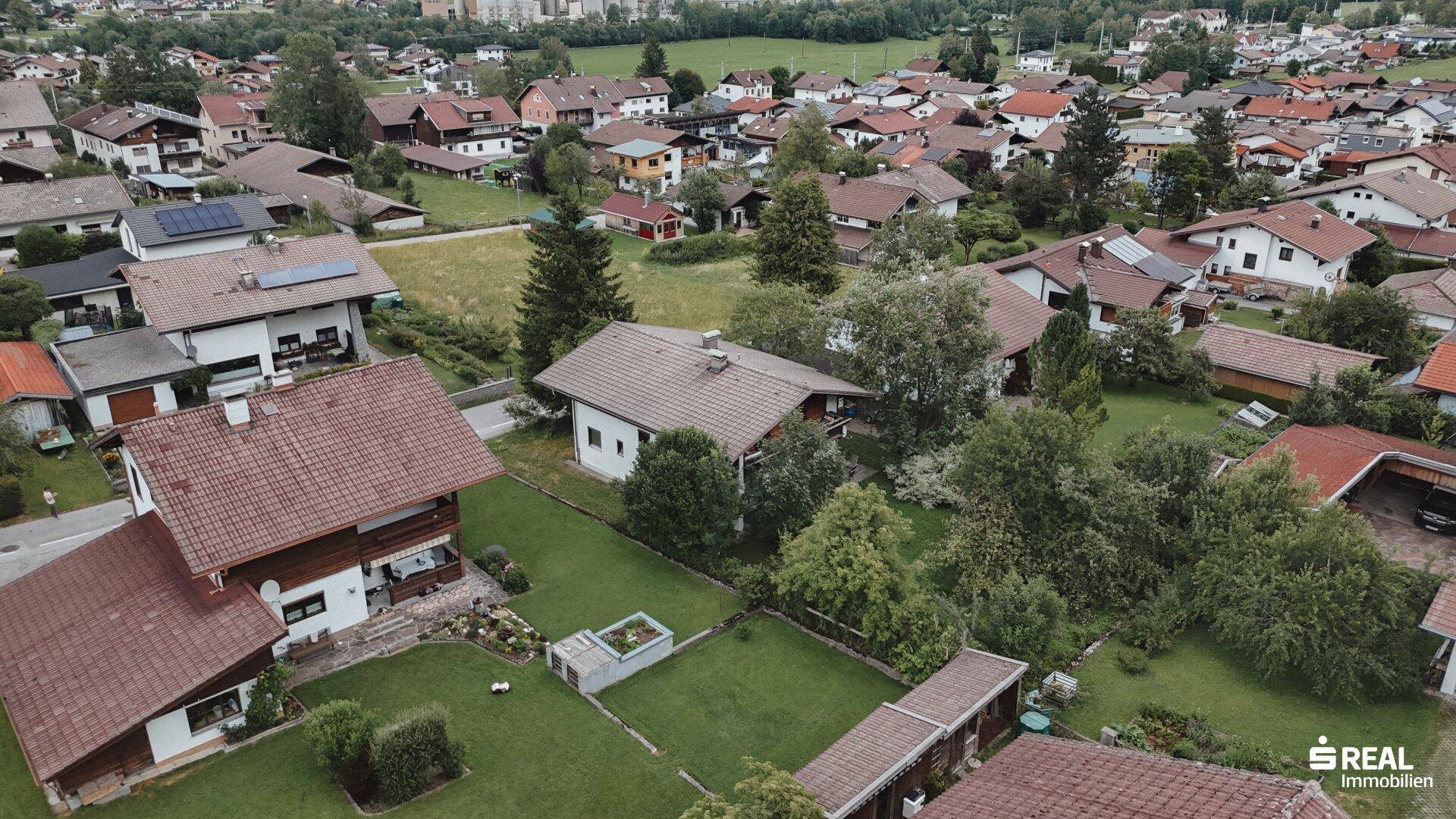 Übersicht über das Anwesen mit großem Garten und angrenzenden Wohnhäusern in grüner Umgebung.