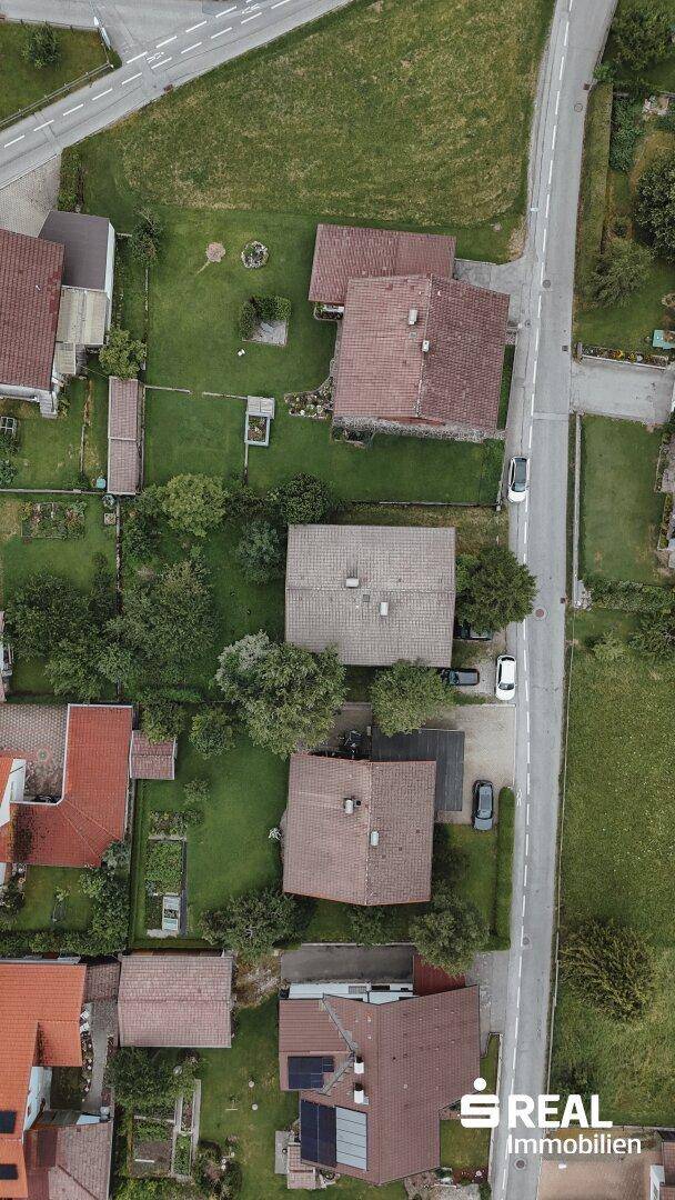 Senkrechte Luftaufnahme des Grundstücks mit Haus, Garten und angrenzender Straße.