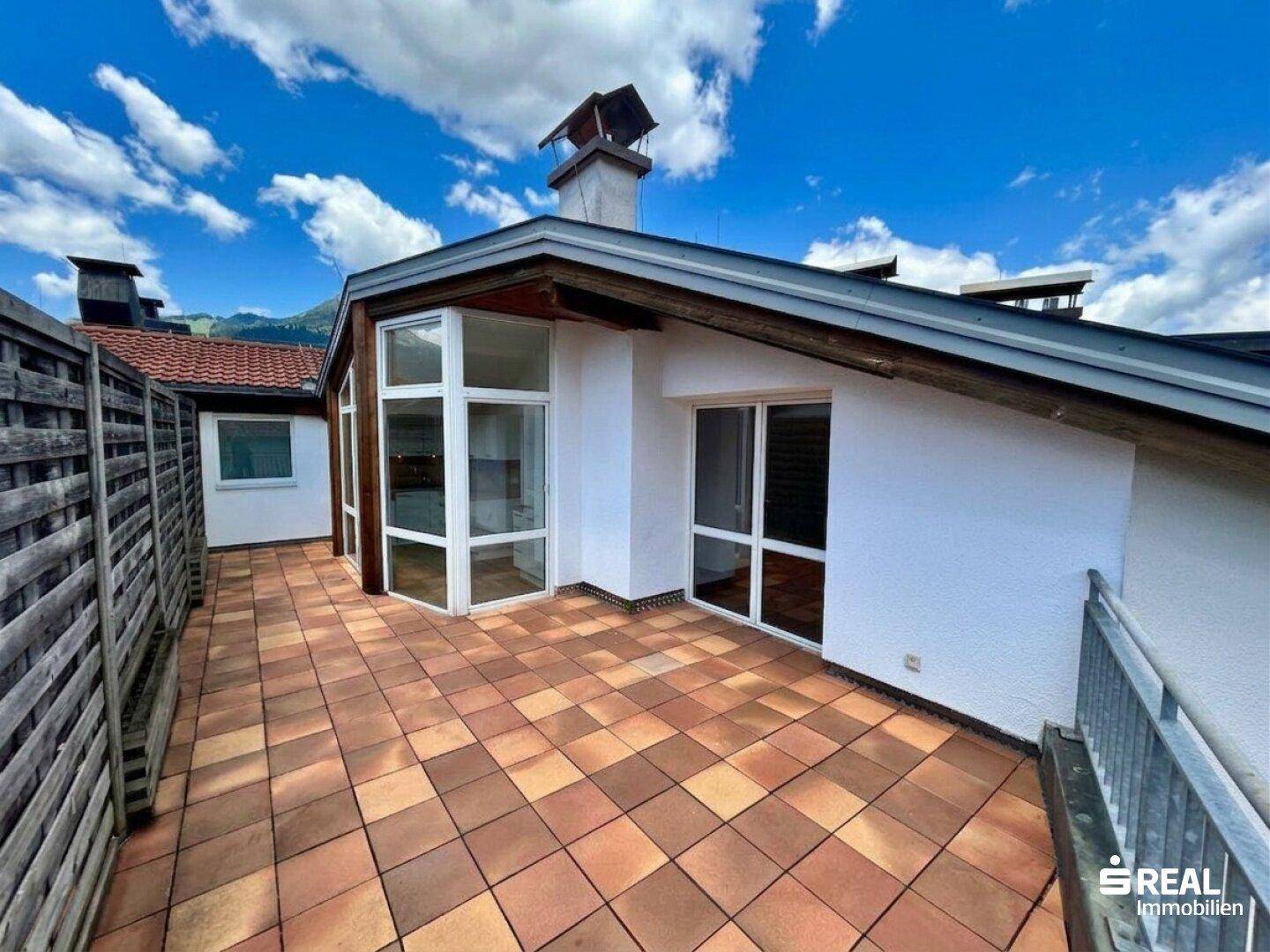 Weitläufige Terrasse mit Blick auf die Berge und die Dachkonstruktion des Gebäudes.