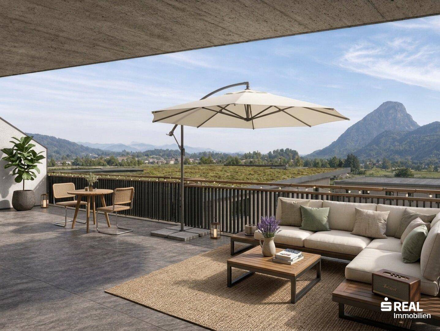 Geräumige Terrasse mit bequemen Loungemöbeln, Sonnenschirm und weitem Blick auf die Berge.