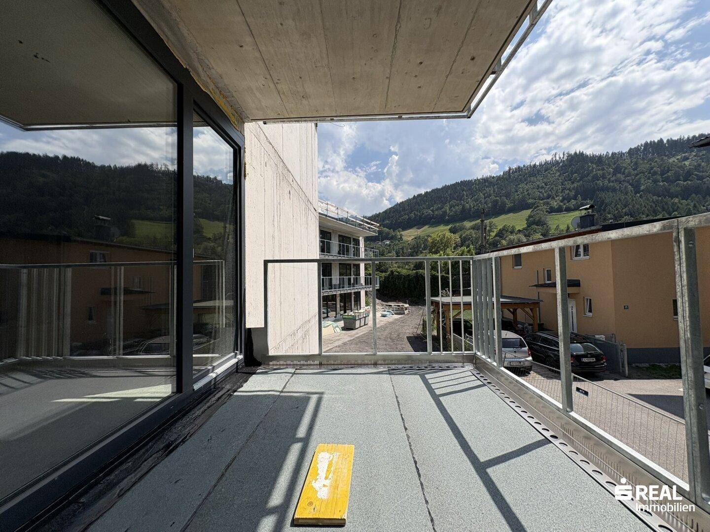 Unfertiger Balkon eines Neubaus mit weitem Blick auf die umliegenden Berge und Täler.