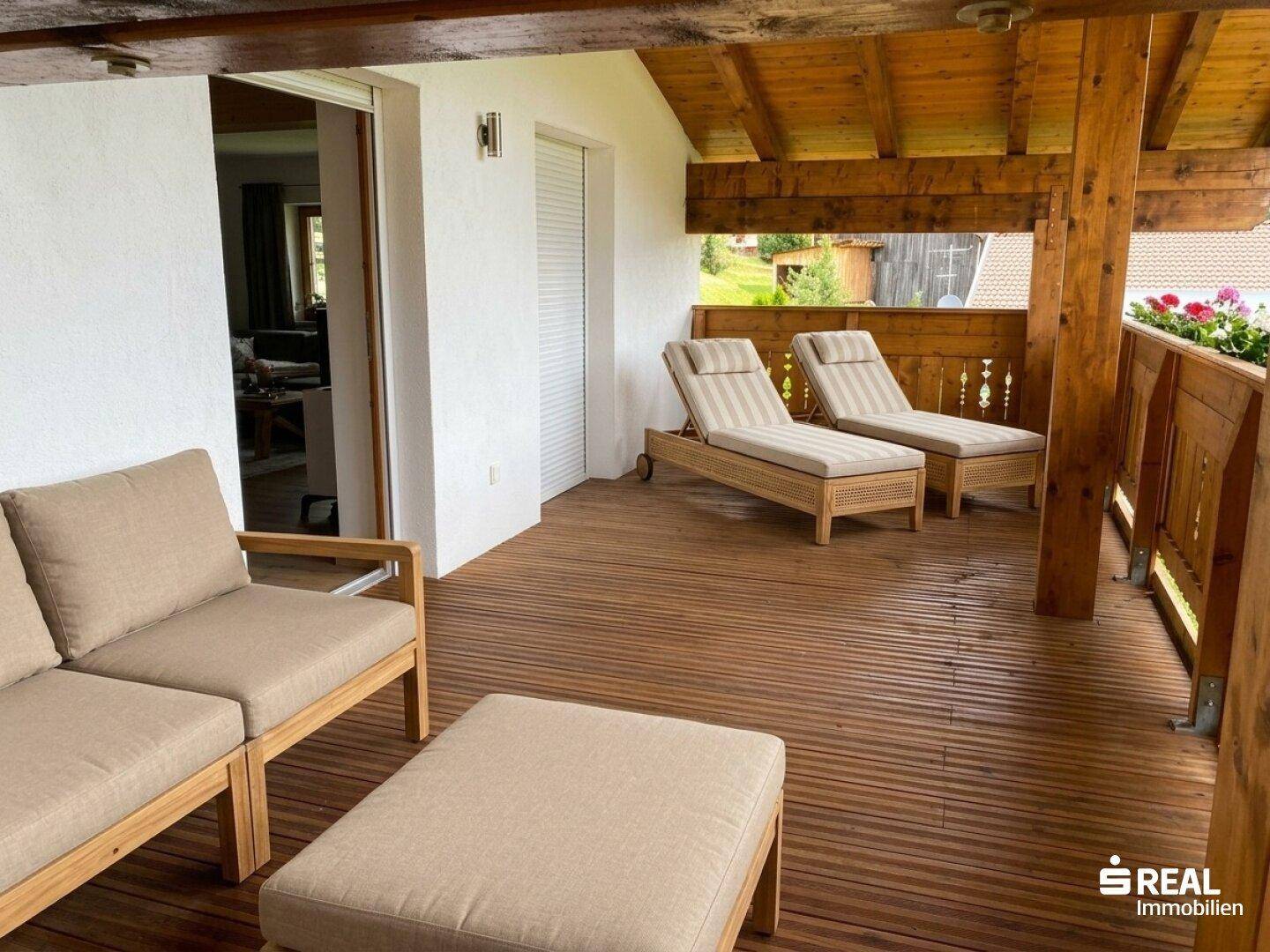 Geräumiger Holzbalkon mit bequemen Liegestühlen und Sitzgelegenheiten zum Entspannen.