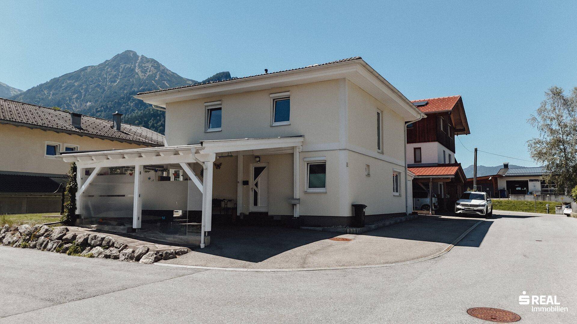 Vorderansicht des Hauses mit Carport und Zufahrt in einer ruhigen Wohngegend.