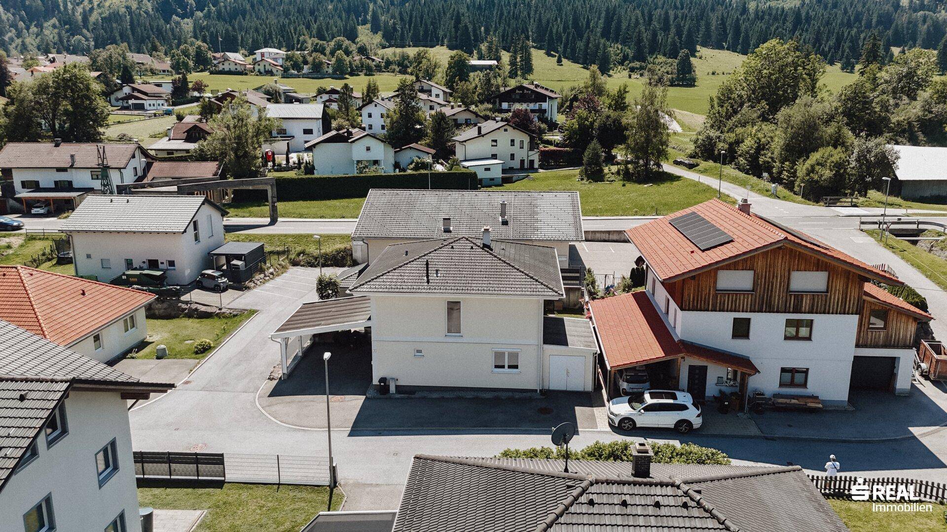 Überblick über die Wohngegend mit Einfamilienhäusern, Gärten und der umgebenden Natur.