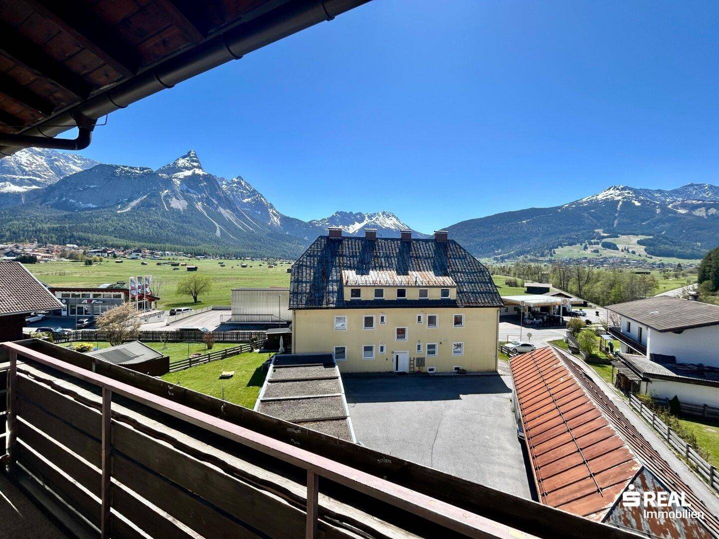 Geräumiger Balkon mit Holzboden und atemberaubendem Blick auf die umliegende Berglandschaft.