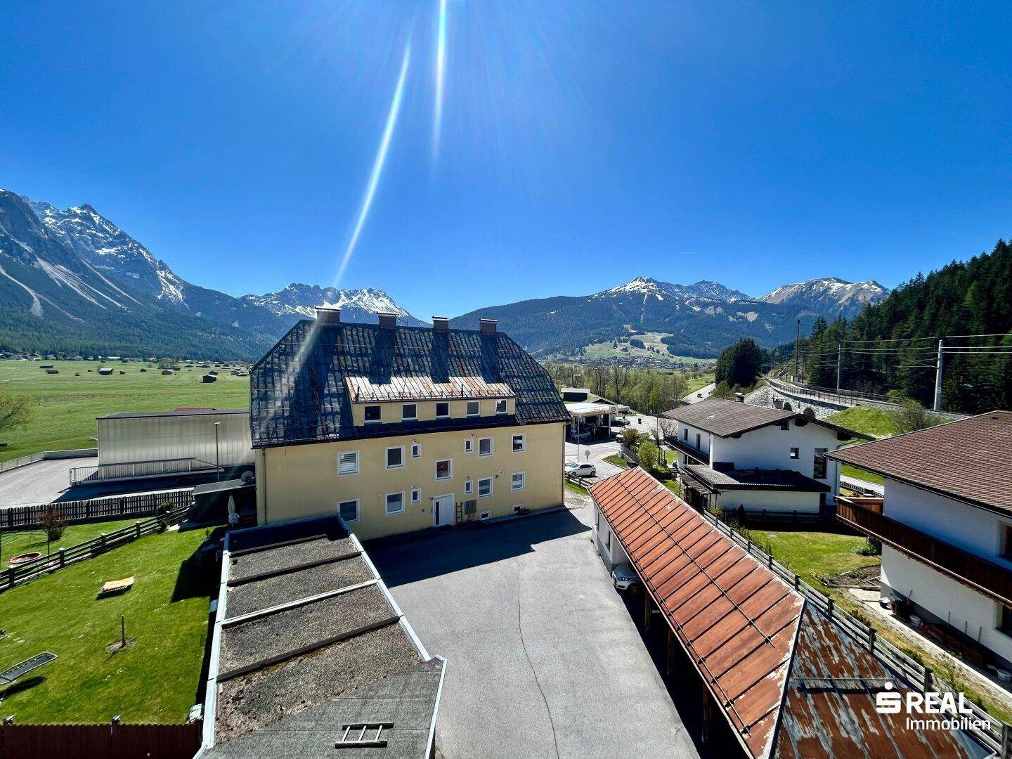 Balkon mit weitem Blick über die Dächer der Nachbarschaft und die beeindruckende Bergkulisse.
