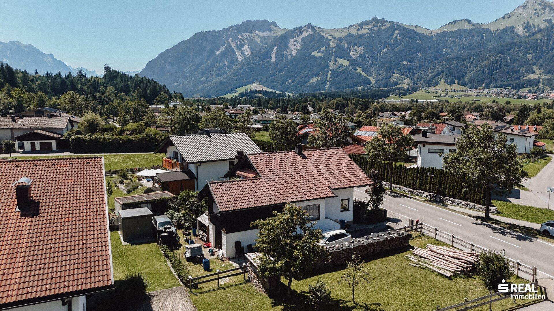 Überblick über das Haus und den Garten, eingebettet in die Nachbarschaft mit Bergblick.