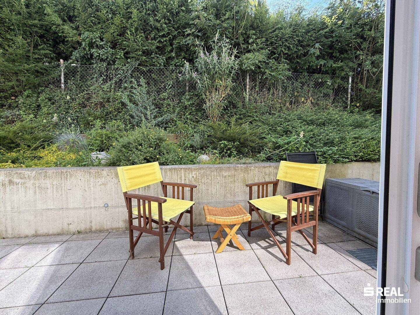 Kleine, private Terrasse mit Gartenmöbeln und umgebender Hecke, bietet Ruhe und Entspannung.