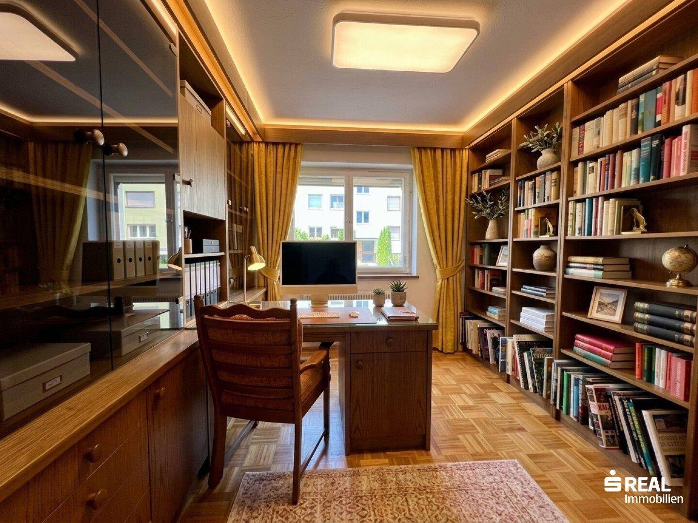 Arbeitszimmer mit Bücherregalen, Schreibtisch und Holzboden.
